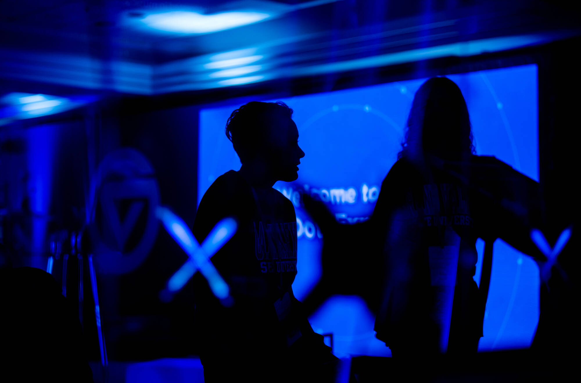 Kate Borgne, a GVSU student with Project Grand Path, silhouetted against a screen at GVSU's Blue Dot Experience